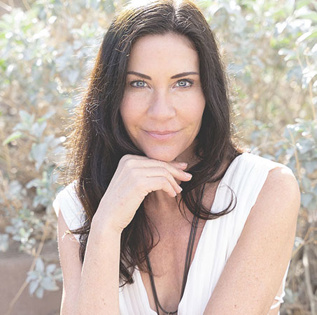 Jewels Arnes seated and smiling, founder of Becoming BioQuantum