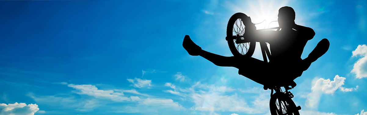 BMX rider mid-air above a ramp during a school assembly